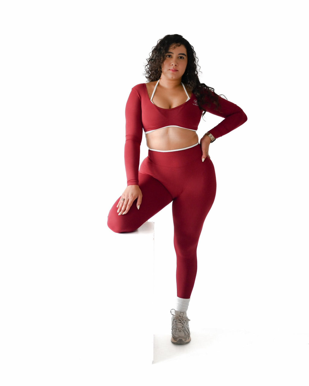 Woman wearing a red athletic outfit on a white background. Vibette Shop